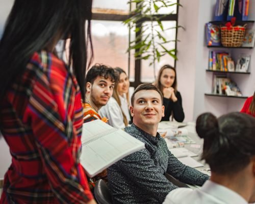 Female teacher explaining subject to her teenage students at language school.